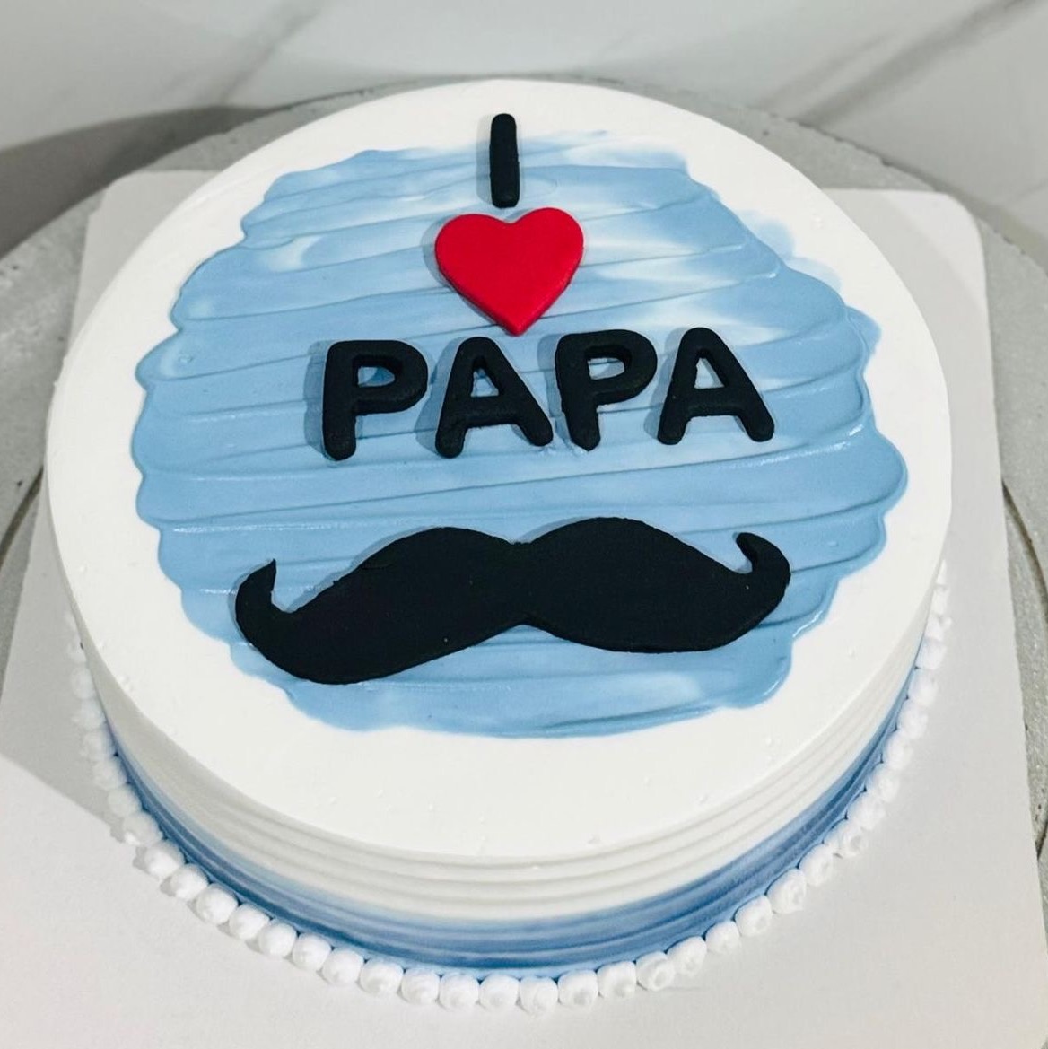 I Love Papa Cake featuring a 1/2 kg pineapple cake with mustache decoration, heart accent and blue white Fathers Day theme by Send My Feelings.