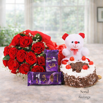12 red roses bouquet with white teddy, Silk chocolates, and black forest cake gift combo